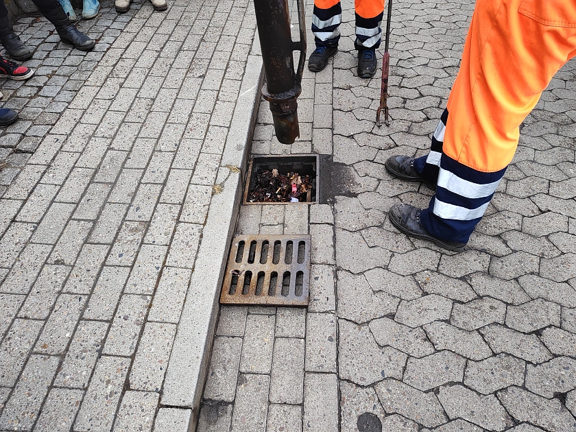 Ein Gully wird von einem Schlauch gereinigt.