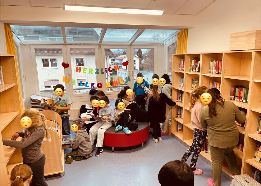 Zahlreiche unkenntlich gemachte Kinder verweilen im Leseclub